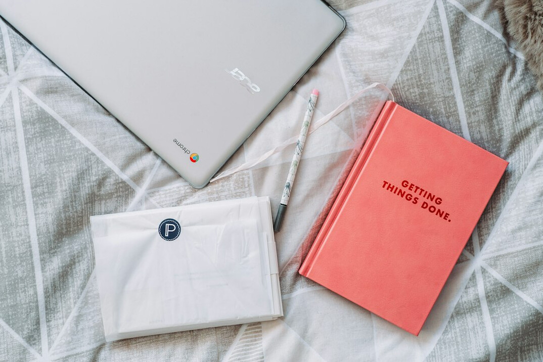 Flat lay of a notebook with programming notes and a laptop